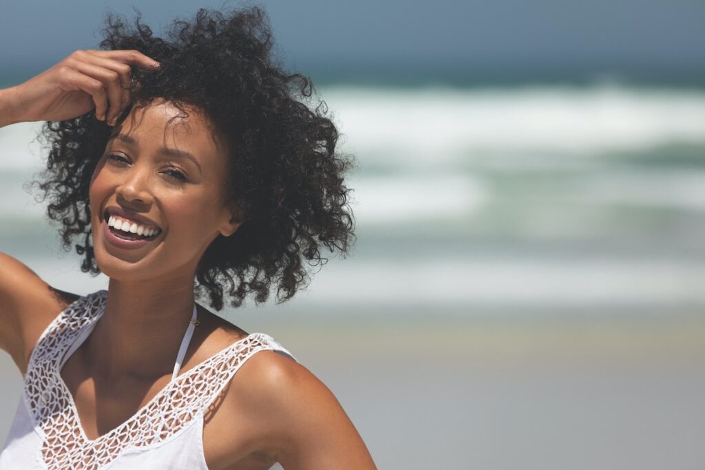 1739909860 happy young woman smiling and standing at beach on Q7SAHEM 1739909860 happy young woman smiling and standing at beach on Q7SAHEM