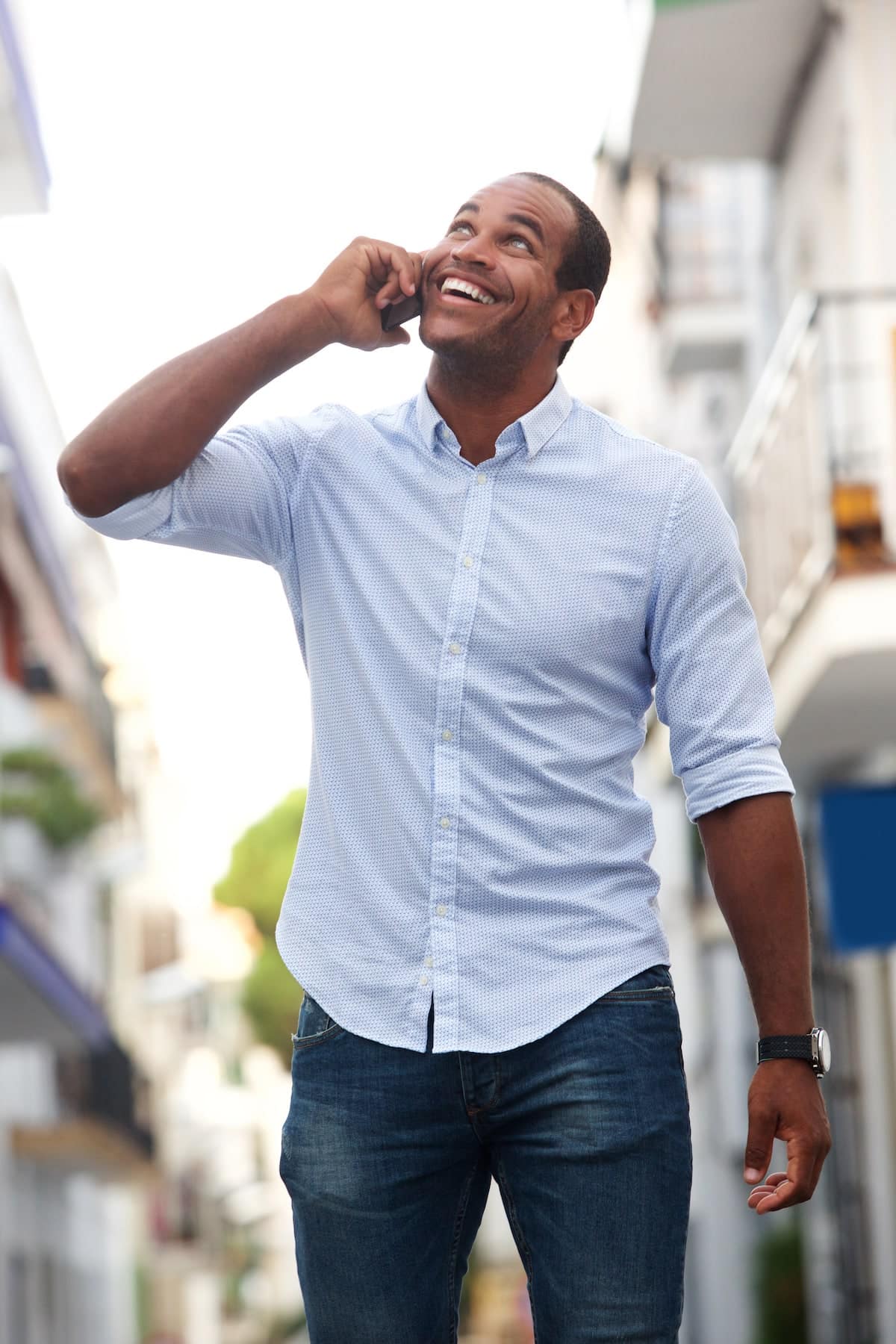 1739909867 happy man walking on street talking on smart phone MBZW2C5 1739909867 happy man walking on street talking on smart phone MBZW2C5
