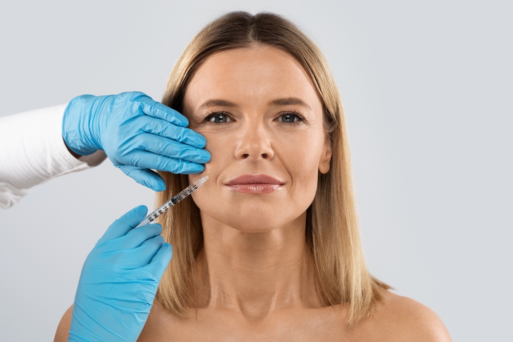 Middle aged woman receives injections to her face for a more balanced appearance.